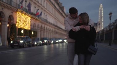 Romantik bir çift, akşam karanlığında Paris sokaklarında, arka planda dönme dolap ile sarılır. Sahne, Fransa 'nın kalbinde bir aşk ve şefkat anı yakalar. Avrupa' nın bir şehrinde seyahat ve turizm sergilenir..