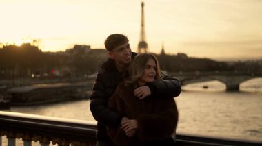 Romantik bir çift, Paris 'te bir köprüde Eyfel Kulesi' ni altın bir günbatımında arka planda görünce aşk seyahati ve Avrupa cazibesini anımsatıyor..