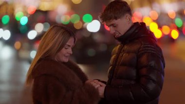 Genç bir çift gece Paris 'te bir şehir caddesinde sarılıyor Bokeh ışıkları romantik bir ortam yaratıyor Fransa' daki iki aşık arasında bir aşk ve bağlantı anı yakalıyor..