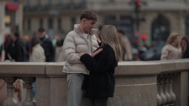 Genç bir çift Paris 'te romantik bir anı paylaşıyor. Erkek ve kadın şehir ortamında şehir sokaklarının ve binaların bulanık arka planıyla kucaklaşıyorlar. Sahne, çift arasında sevgi ve şefkat dolu bir anı yakalıyor..