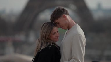 Genç bir çift, Paris 'te Eiffel Kulesi' nin arka planında bulanık bir şekilde sevgi dolu bir şekilde kucaklaşır. Sahne, aşıklar ve birliktelikleri arasındaki yolculukları sırasında romantik bir anı yakalar..