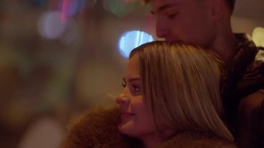 Gece Paris 'te romantik bir çift kadının alnını öper. Adam hassas bir anda sığ bir alan derinliği ve bokeh ışıkları ile sıcak, samimi bir atmosfer yaratır..