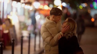 Genç bir çift gece Paris 'te bir bankta kucaklaşır. Yumuşak Bokeh ışıkları romantik bir ortam yaratır. Aşıklar el kamerasıyla birbirlerini çekmekten hoşlanırlar..