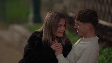 Paris 'te genç romantik bir çift el ele tutuşuyor ve birbirlerine sevgiyle bakıyorlar çift açık hava ortamında sevgi ve beraberliğin tadını çıkarıyorlar..