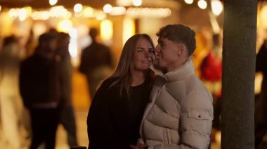 Genç bir çift gece Paris 'te kucaklaşıyor aşıklar el ele tutuşuyor ve birbirlerine sevgiyle bakıyorlar sahne açık havada romantik bir ortam yaratıyor..