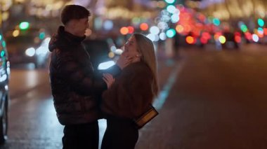 Genç bir çift gece Paris 'te bir caddede sarılır. Arka planda şehir ışıkları bulanıklaşır. Romantik bir atmosfer yaratır..