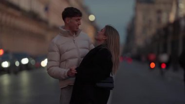 Günbatımında Paris 'te genç bir çift, Fransa' nın bir caddesinde sarılıyor..