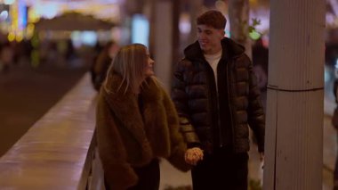 Genç bir çift gece Paris 'te, Fransa' da el ele yürür aşıklar, arka planda şehir ışıklarıyla romantik bir gezintiye çıkarlar..