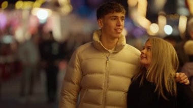 Genç bir çift gece Paris 'te kol kola yürür. Romantik erkek ve kadın, arka planda Bokeh ışıkları ile akşam yürüyüşünün tadını çıkarırlar. Neşeli ve sıcak bir atmosfer yaratırlar..