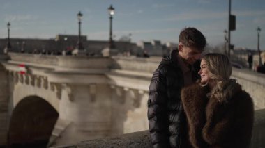 Paris 'teki Pont Neuf Köprüsü' nde sevgi dolu bir çift, kadın ve erkek, güneşli bir günde Avrupa başkentinde romantik bir anın tadını çıkarırlar..