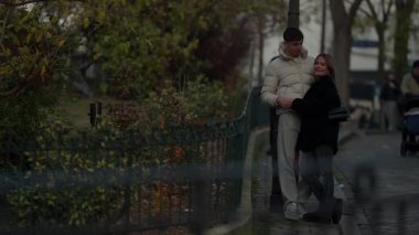 Genç bir çift yağmurlu bir günde Paris 'te bir sokak lambasının yanında kucaklaşırken görülüyor. Aşıklar şehir ortamında sevgi ve beraberlik sergiliyorlar..