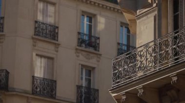 Klasik bir Fransız binasının balkonları ve pencerelerinin yer aldığı Paris mimarisinin yakın çekim görüntüleri demirciliği süslüyor ve Paris Fransa 'da romantik bir şehir manzarasının kurulumunu sağlıyor..