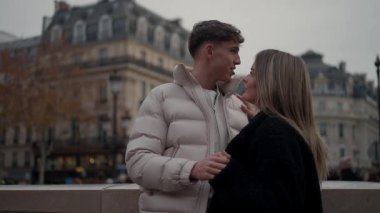 Genç bir çift Paris 'te el ele tutuşurken görülüyor. Kadın ve erkek, arka planda Paris mimarisi ile yan yana duruyorlar. Bu sahne, Avrupa' daki bir şehirde sevgi ve sevgiyi aktarıyor..