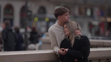 Genç bir çift Paris 'te sarılıyor kadın ve erkek, bulanık bir şehir geçmişiyle sevgi dolu bir şekilde sarılıyorlar. Bu sahne, yolculukları sırasında romantik bir aşk ve beraberlik anını yakalıyor..