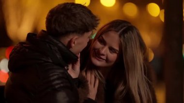 Geceleri Paris 'te romantik bir çift, yumuşak bir odak ve bokeh ışıklarıyla sarılır sıcak bir atmosfer yaratır..