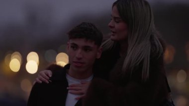 Genç bir çift alacakaranlıkta Paris 'te sarılıyor kadın başını omzuna dayayan adama sarılıyor Bokeh ışıkları arka planda romantik bir atmosfer yaratıyor klip Fransa' nın kalbinde bir sevgi ve şefkat anı yakalıyor..