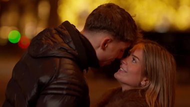 Paris 'te romantik bir çift geceleyin Fransa' da genç bir adam ve kadın birbirlerine aşıklar şehir ışıklarıyla bakıyorlar ve sahte bir arkaplan oluşturuyorlar..