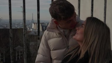 Paris 'te genç bir çift, arka planda Eyfel Kulesi olan Fransa' da samimi bir anı paylaşıyor. Aşıklar Montmartre Tepesi 'nin manzarasıyla kucaklaşıyorlar..