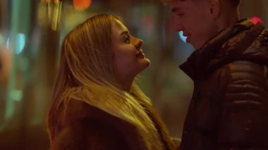 Genç bir çift, geceleri Paris sokaklarında tutkulu bir öpüşmeyi paylaşıyor. Sahne, yumuşak bokeh ışıklarıyla aydınlatılıyor. Aşıklar kucaklaşırken romantik ve samimi bir ortam yaratıyor..