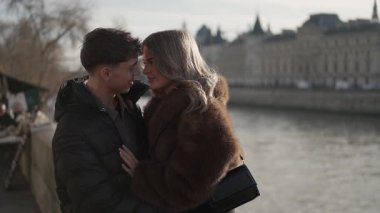 Genç bir çift Paris 'te Seine nehrinin kıyısında kucaklaşır kadın ve erkek birbirine aşık olur ve arka plandaki şehir manzarasıyla birlikte vakit geçirirler..