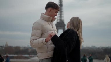 Romantik bir çift Paris 'te arka planda Eyfel Kulesi ile el ele tutuşuyor. Genç aşıklar birlikte vakit geçiriyorlar. Bir seyahat ve aşk konsepti sergiliyorlar..