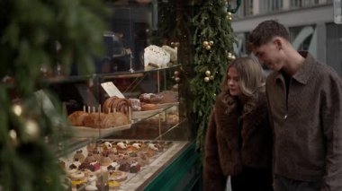 Genç bir çift Noel zamanı Paris 'te bir pastanede vitrinlere bakarlar aşıklar pastane vitrinindeki tatlılara ve tatlılara hayran kalırlar..