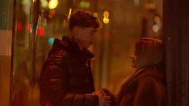 Birbirine aşık genç bir çift, Paris 'te bir sokakta el kamerasıyla arka planda Bokeh ışıkları ile samimi bir anı paylaşan bir erkek ve kadının fotoğrafını çeker..