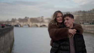 Seine Nehri ve Pont Neuf köprüsü arka planda görünür bir şekilde Paris 'te sevgi dolu bir çift, popüler bir seyahat noktasında bir sevgi ve beraberlik anı yakalar..