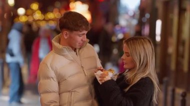 Genç bir çift, Paris 'te romantik bir gecede yemeklerini paylaşıyor. El kamerası, Avrupa' daki tatillerinde sokak yemeklerinden zevk alan erkek ve kadın arasındaki sevgi ve neşeyi yakalıyor..