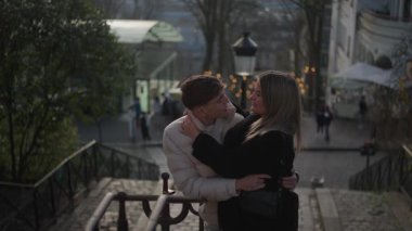 Genç bir çift Paris 'te Montmartre' nin merdivenlerinde kucaklaşır. Aşıklar şehir ışıklarına sevgiyle sarılır. Romantik bir zemin sağlar..