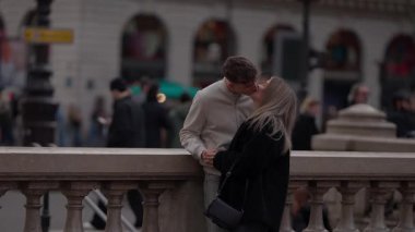 Paris 'te Fransa' da Seine nehrinin kıyısında romantik bir çift öpüşür aşıklar şehrin bulanık arka planıyla kucaklaşır bir Avrupa tatili sırasında bir yakınlık ve yakınlık anı yakalar..