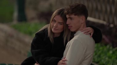 Genç bir çift, Paris 'te bir parkta kucaklaşır. Kadın, erkek arkadaşına arkadan sarılır. Sevgisini ve sevgisini açık havada gösterir..