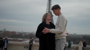 Paris 'te arka planda Eyfel Kulesi olan romantik bir çift Avrupa' nın popüler bir tatil beldesinde aşıkların yavaş çekim görüntülerini gösteriyor..