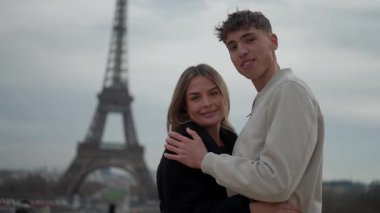 Genç bir çift, Paris 'te arka planda belirgin bir şekilde sergilenen Eyfel Kulesi' ne sevgiyle sarılır. Sahne, yolculukları sırasında bir aşk ve beraberlik anı yakalar..