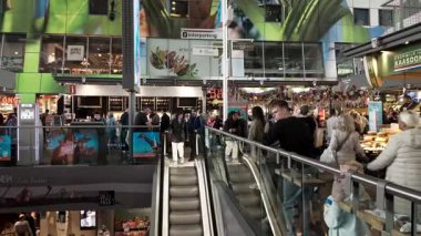 ROTTERDAM, NETHERLANDS - 13 Eylül 2025 - İnsanlar canlı Markthal Rotterdam kapalı pazar yerinde alışveriş ve yürüyüş