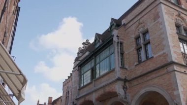 BRUGES, BELGIUM - 15 Eylül 2025 - Bruges, Belçika 'da kemerli pencereleri ve dekoratif detayları olan geleneksel tuğla bina