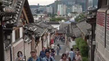 SEOUL, Güney Kore - 11 Ekim 2025 - Geleneksel Kore köyü sokaklarında yürüyen insanlar eski taş duvarları modern binalarla harmanlıyor