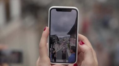 SEOUL, Güney Kore - 11 Ekim 2025 Seul, Güney Kore 'de geleneksel sokakları ziyaret eden insanları gösteren akıllı telefonlar.