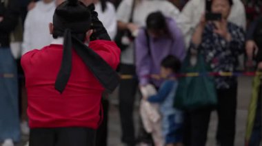 SEOUL, Güney Kore - 11 Ekim 2025 - Kırmızı üniformalı geleneksel muhafız kültürel bir etkinlik sırasında izleyicileri izliyor