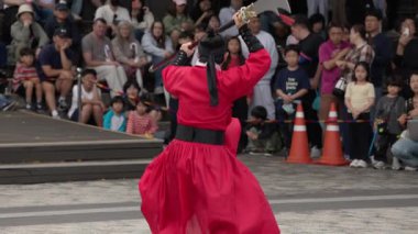 SEOUL, Güney Kore - 11 Ekim 2025 - Geleneksel Kore dövüş sanatları gösterisine katılan kırmızı kostümlü bir sanatçı