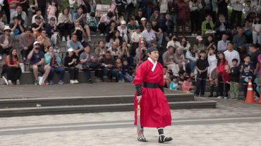 SEOUL, Güney Kore - 11 Ekim 2025 - Geleneksel kıyafet giymiş Koreli bir adam kalabalığa dövüş sanatları gösterisi yapıyor