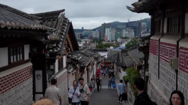 SEOUL, Güney Kore - 11 Ekim 2025 - Bukchon Hanok Köyü tarihi caddesinde yürüyen insanlar