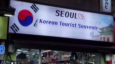 SEOUL, Güney Kore - 11 Ekim 2025 - Kore bayrağını ve geleneksel mimariyi bir turist hediyelik eşya dükkanının üstünde gösteren ışıklı tabela