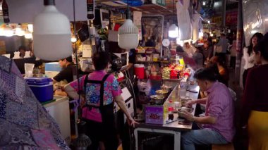 SEOUL, Güney Kore - 11 Ekim 2025 Seul, Güney Kore 'deki canlı bir gece pazarında sokak yemekleri yiyen insanlar