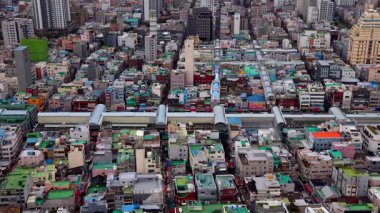 BUSAN, Güney Kore - 10 Ekim 2025 - Yoğun binalarla Busan şehir manzarası ve raylarda yükseltilmiş bir tren