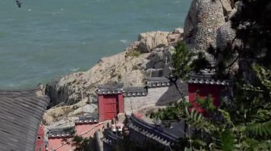 BUSAN, Güney Kore - 10 Ekim 2025 - Haedong Yonggungsa Tapınağı Deniz manzaralı kayalık bir sahil şeridi üzerine inşa edildi