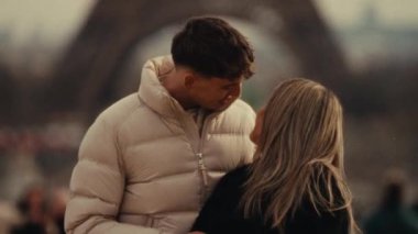 Romantik bir şehir gezisi. Paris 'te, arka planda Eyfel Kulesi olan bir çift, el kamerası ve bulanık seyahat vlogları belgeselleri ve ticari projelerle çekiliyor.