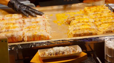 Satıcı Seul 'deki bir gece pazarında lezzetli sokak yemekleri hazırlıyor.