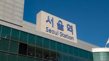 Seul İstasyonu açık mavi gökyüzünün altındaki modern bir binanın ön cephesinde.