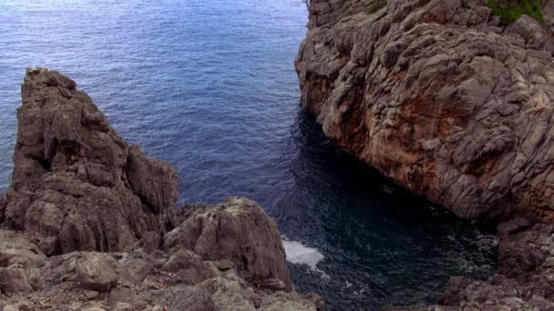 Eau bleu foncé sur une côte rocheuse — Video